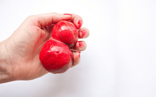 A hand holds fruit symbolizing Epididymitis